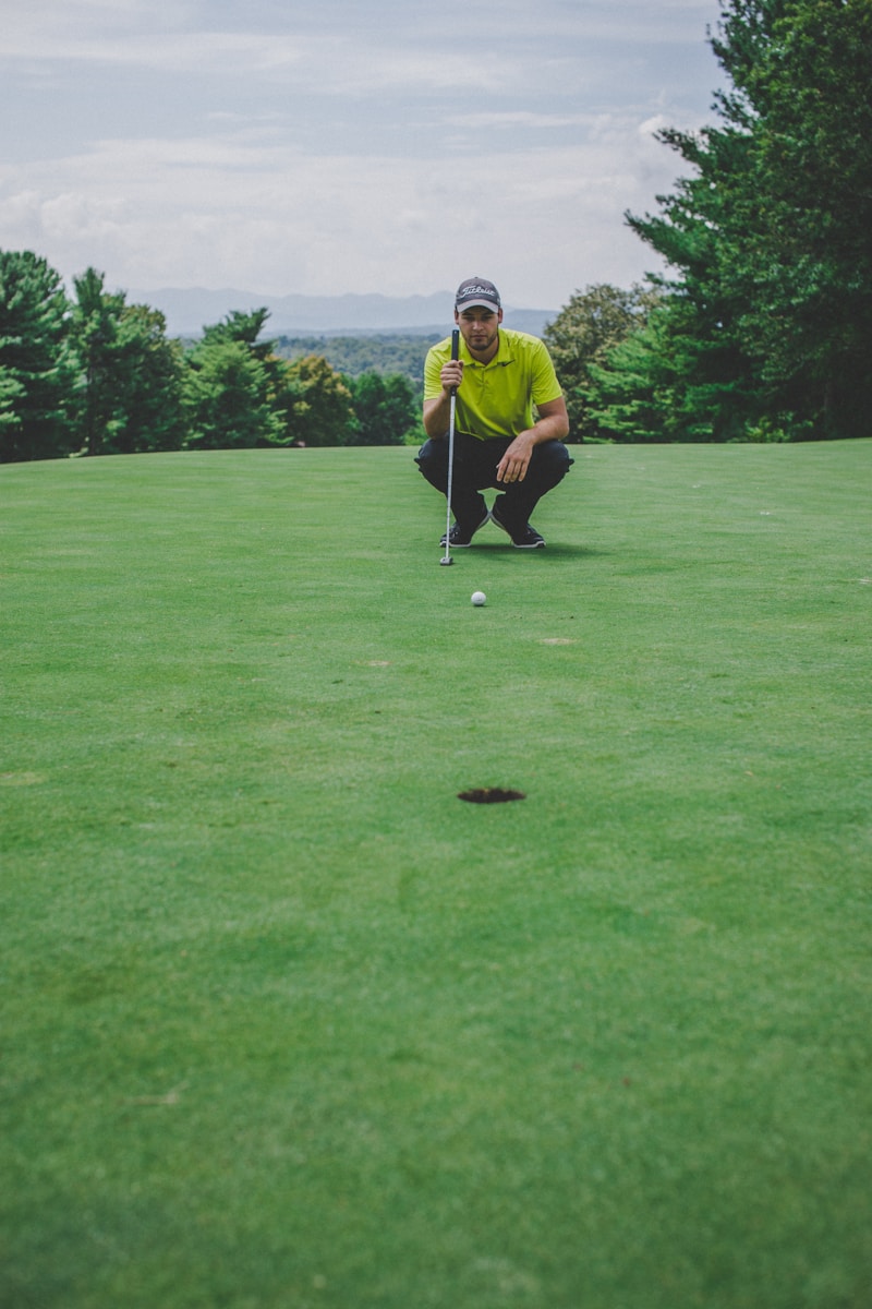 Photo by Courtney Cook man playing golf sitting beside trees